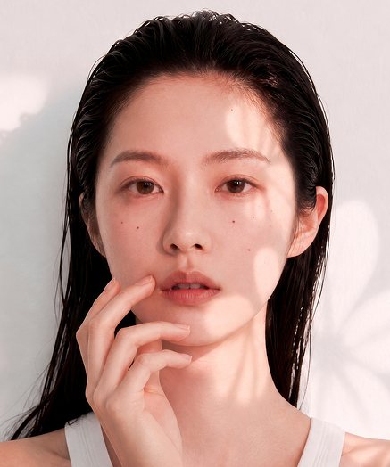 광고 모델 — 젖은 머리, 손끝을 턱에 댄 정면 여성